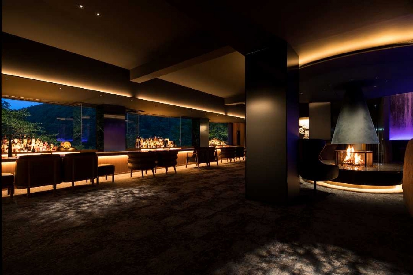 店内:箱根の自然を目の前にするチーク材バーカウンター。中央には直径2.2mの鉄紺の暖炉が鎮座しソファやデイベットと共に寛ぎの時間を演出。